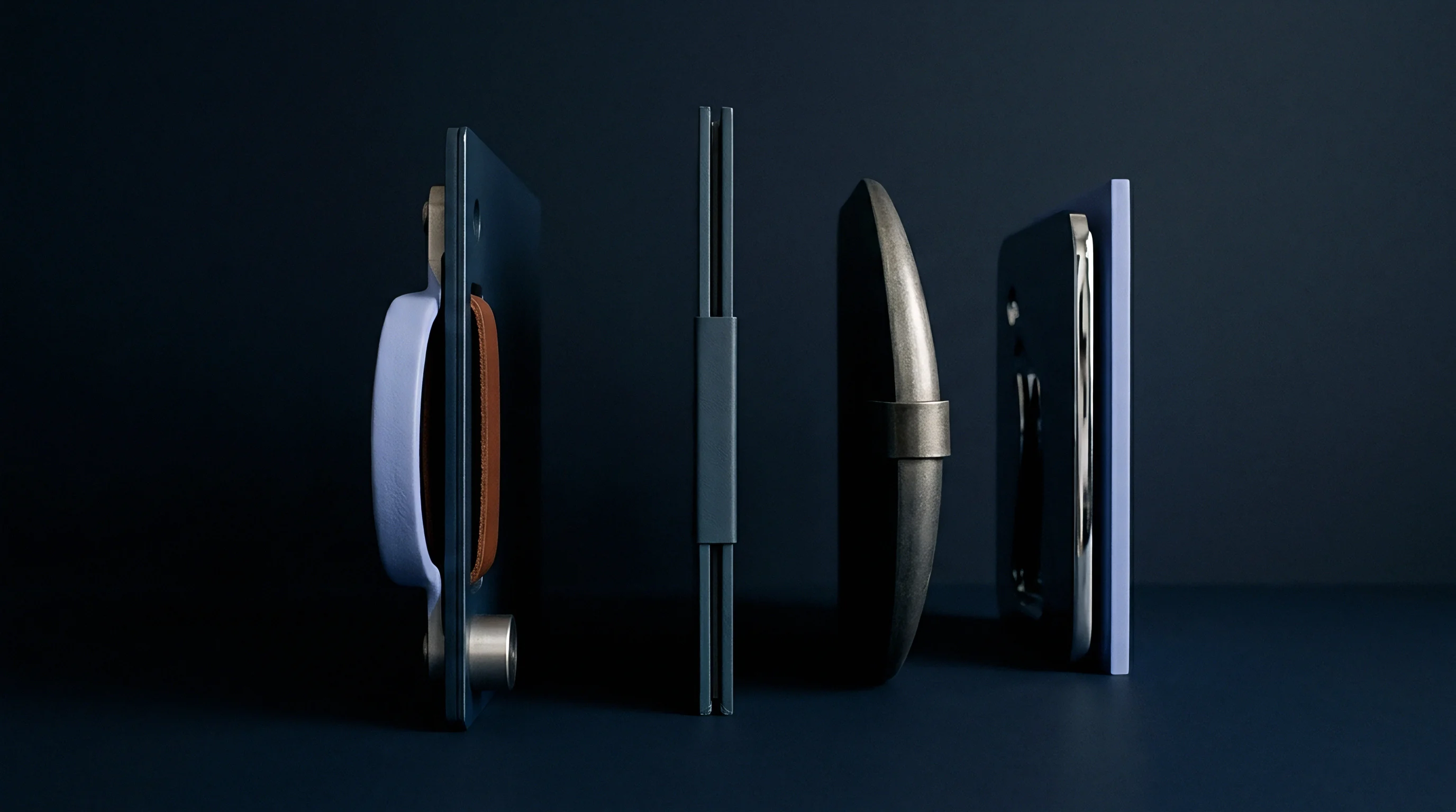 Four minimalist product prototypes stand in profile against a solid dark surface displaying structural variations in packaging materials and assembly methods.