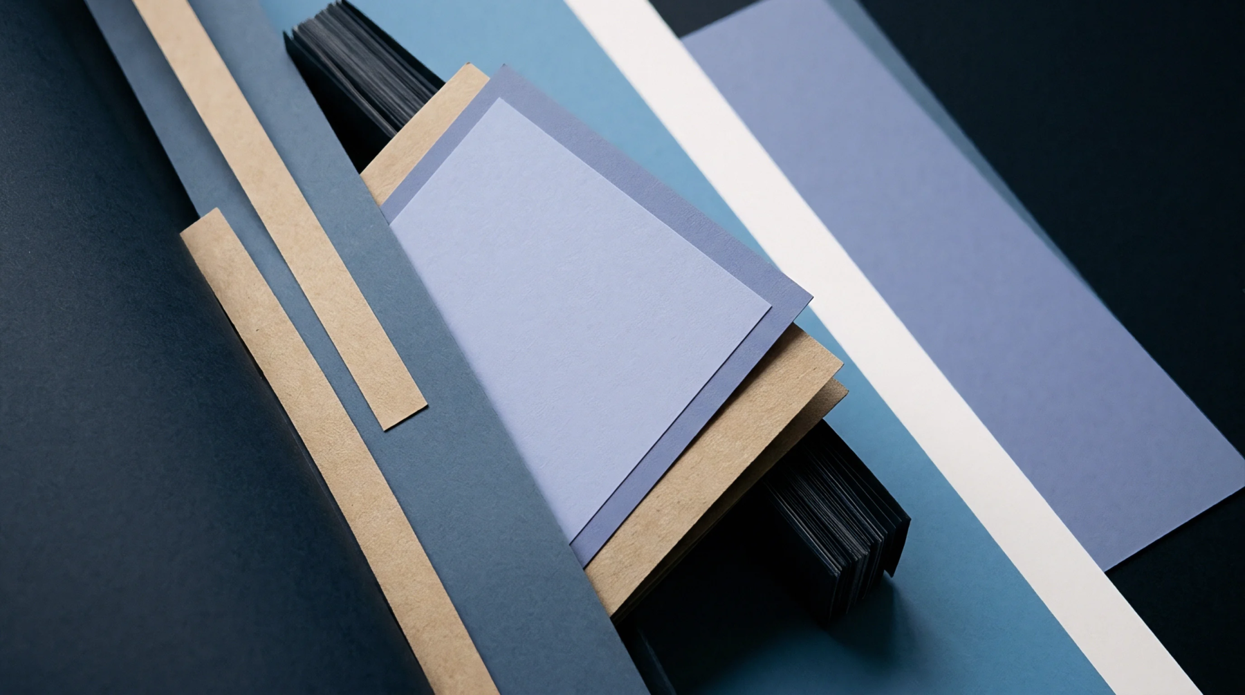 Multiple paper sheets of varying colors weights and sizes are arranged diagonally across the frame showing different uncoated and kraft substrates.